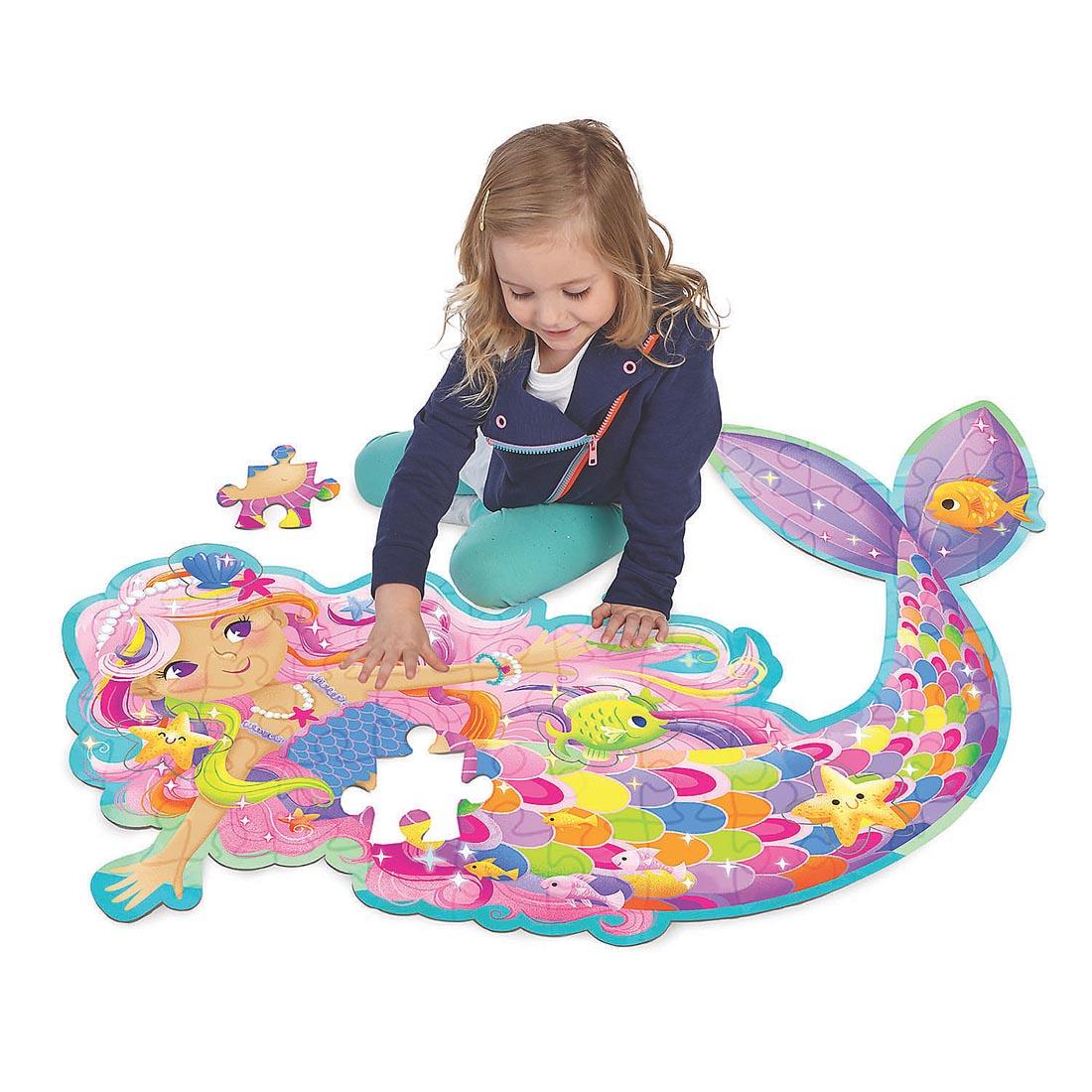 Child completing the Magical Mermaid Floor Puzzle by Peaceable Kingdom