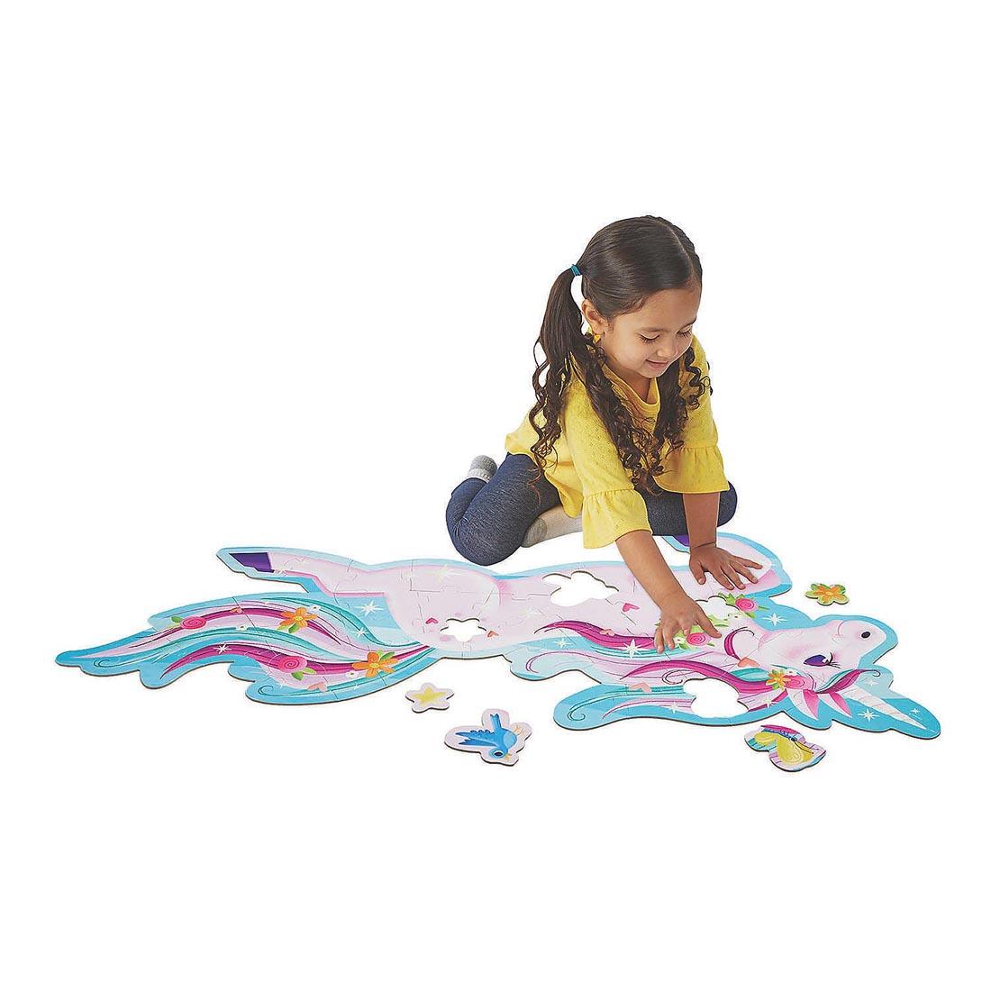 Child completing the Unicorn Floor Puzzle by Peaceable Kingdom