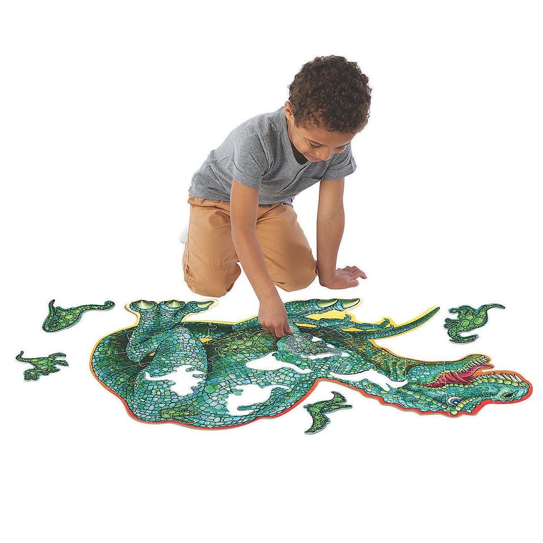 Child completing the Dinosaur Floor Puzzle by Peaceable Kingdom