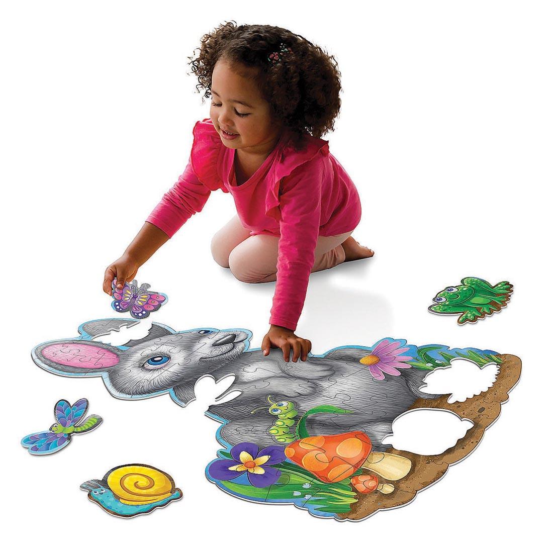 Child completing the Bunny Floor Puzzle by Peaceable Kingdom