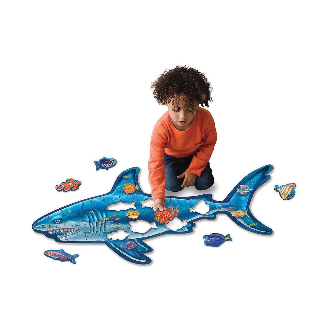 child completing the Shark Floor Puzzle By Peaceable Kingdom