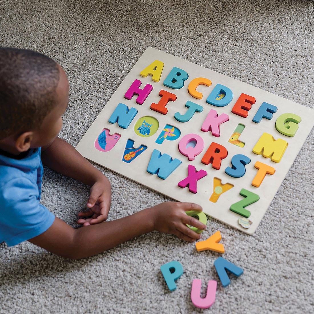 child completing the Wood Alphabet Tray Puzzle By Peaceable Kingdom