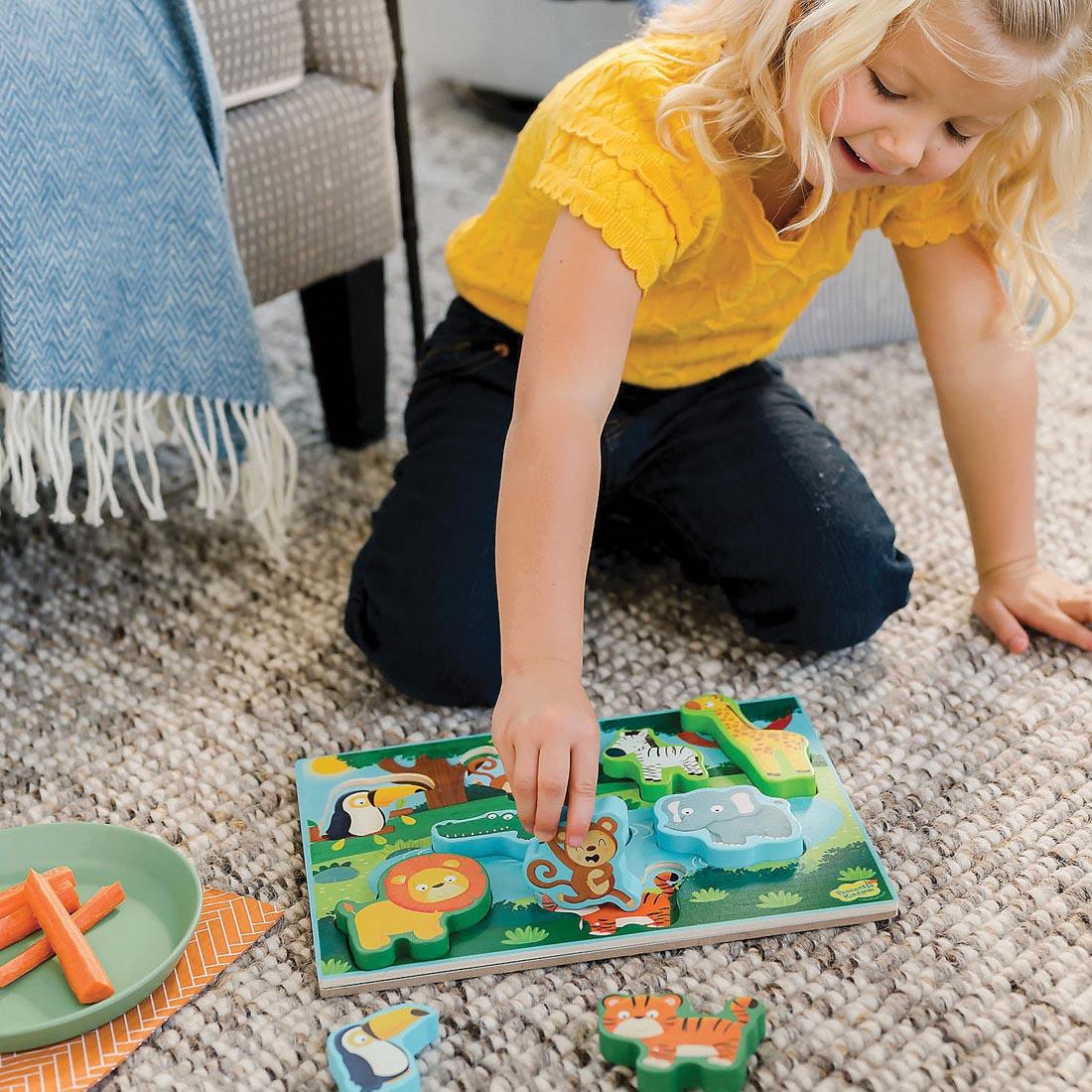 child sitting on the floor playing with My First Wooden Puzzle: Jungle By Peaceable Kingdom