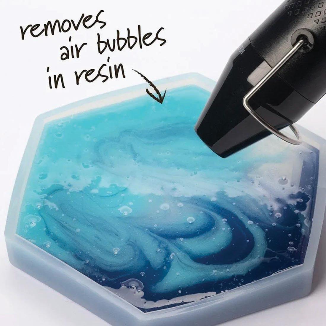 tip of Plaid Multi-Use Heat Pen hovering over a mold full of resin with text: removes air bubbles in resin