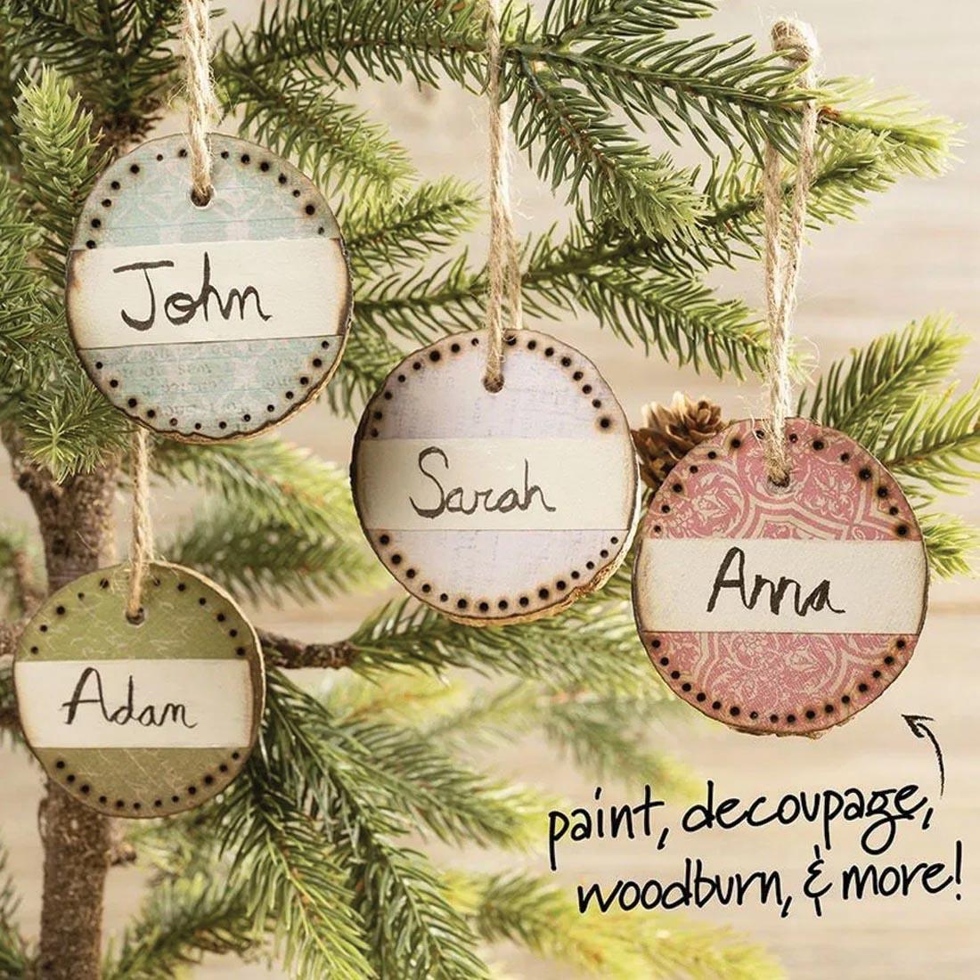 4 examples of decoreated Wood Slice Ornaments hanging on a tree, with text: paint, decoupage, woodburn & more!