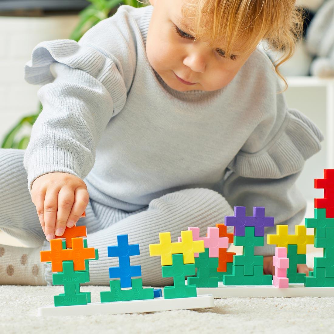 child playing with pieces from the Plus-Plus BIG Learn To Build Activity Set