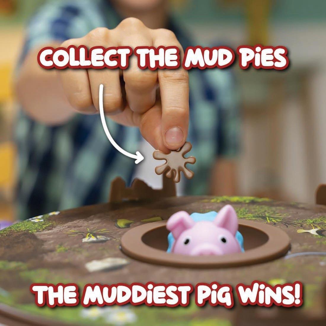 child's hand holding a piece from Pigs on Trampolines Board Game plus text collect the mudpies; the muddiest pig wins!