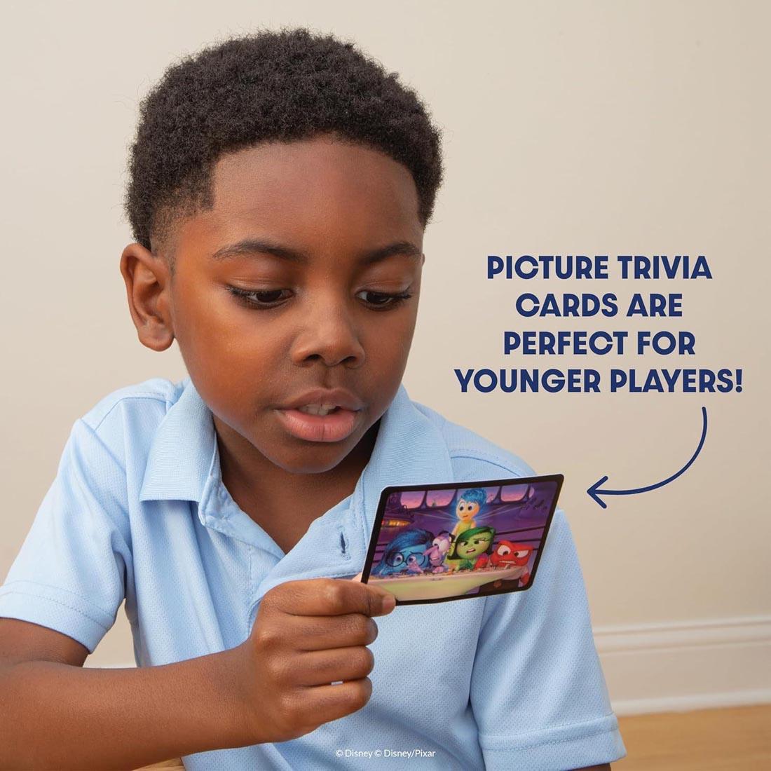 child looking at a card from The Magical World Of Disney Trivia Kids Edition Game plus text picture trivia cards are perfect for younger players!