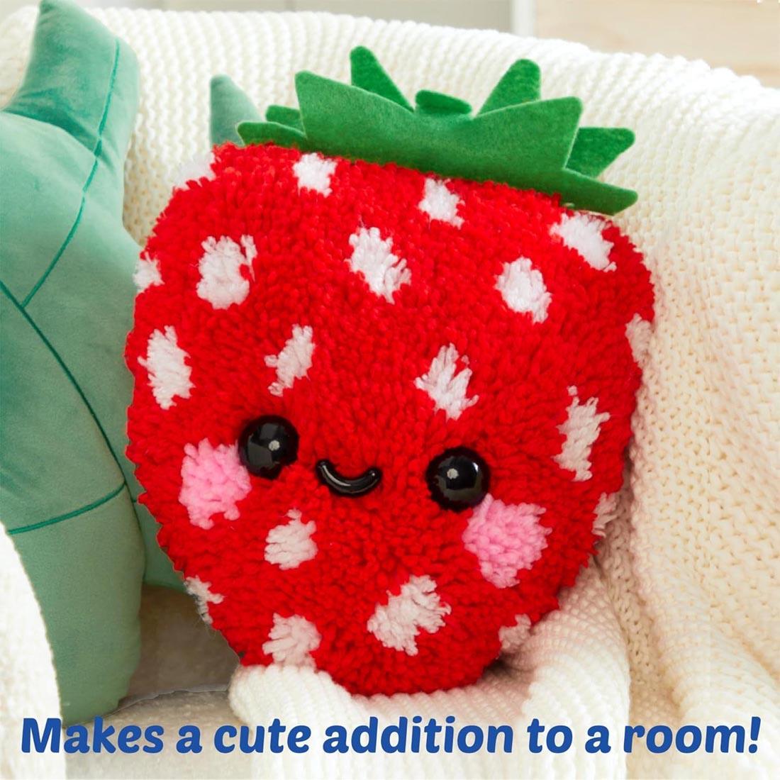 completed example of a Make A Strawberry Latch Hook Pillow by Craft-Tastic plus text Makes a cute addition to a room!