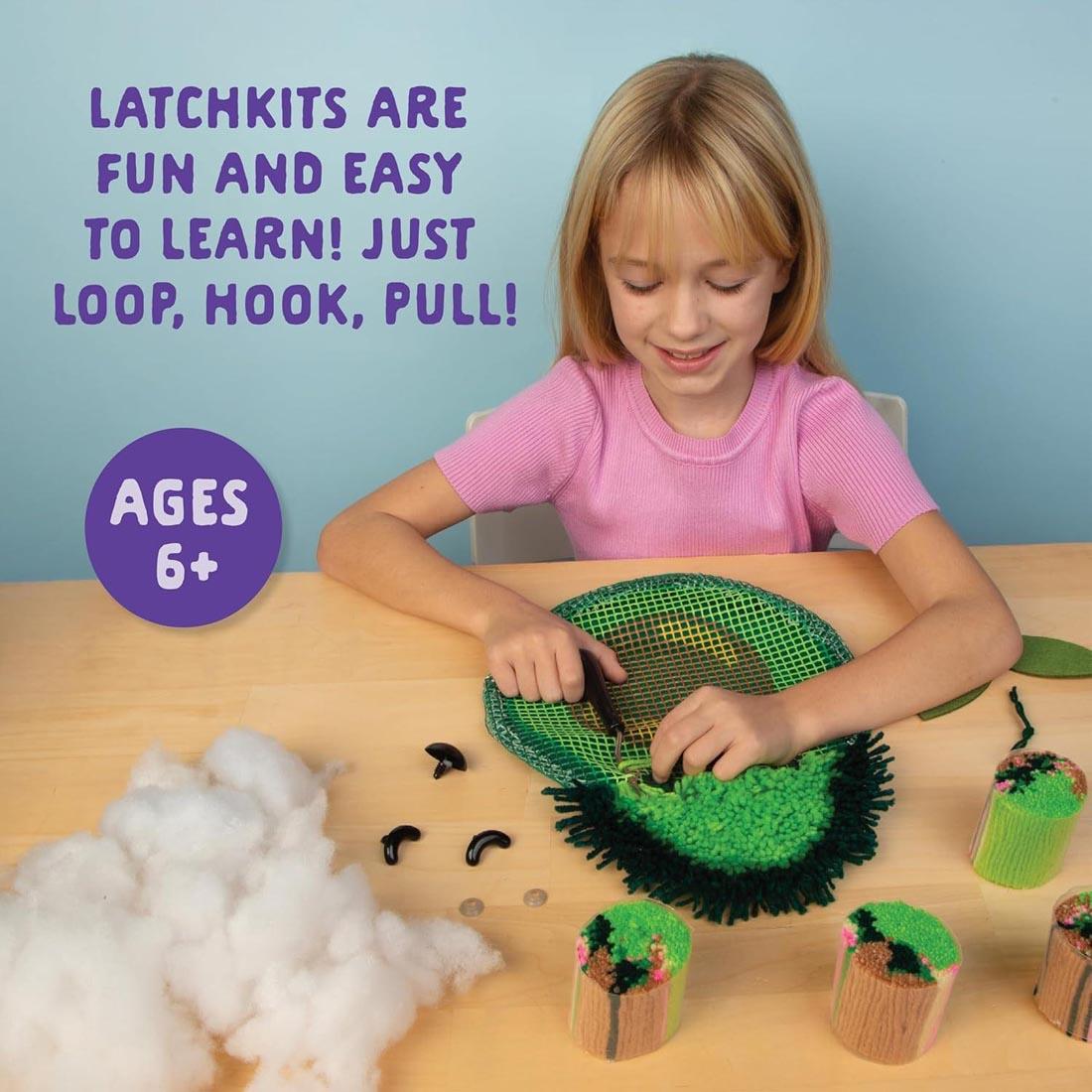 child working on Make An Avocado Latch Hook Pillow by Craft-Tastic plus text Latchkits are fun and easy to learn! Just loop, hook, pull! Ages 6+