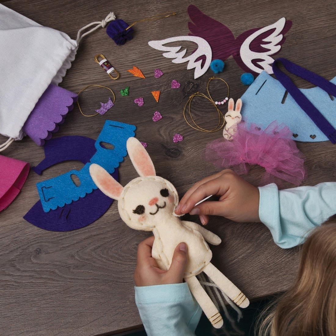 child's hands creating with the Make A Bunny Friend Kit by Craft-Tastic