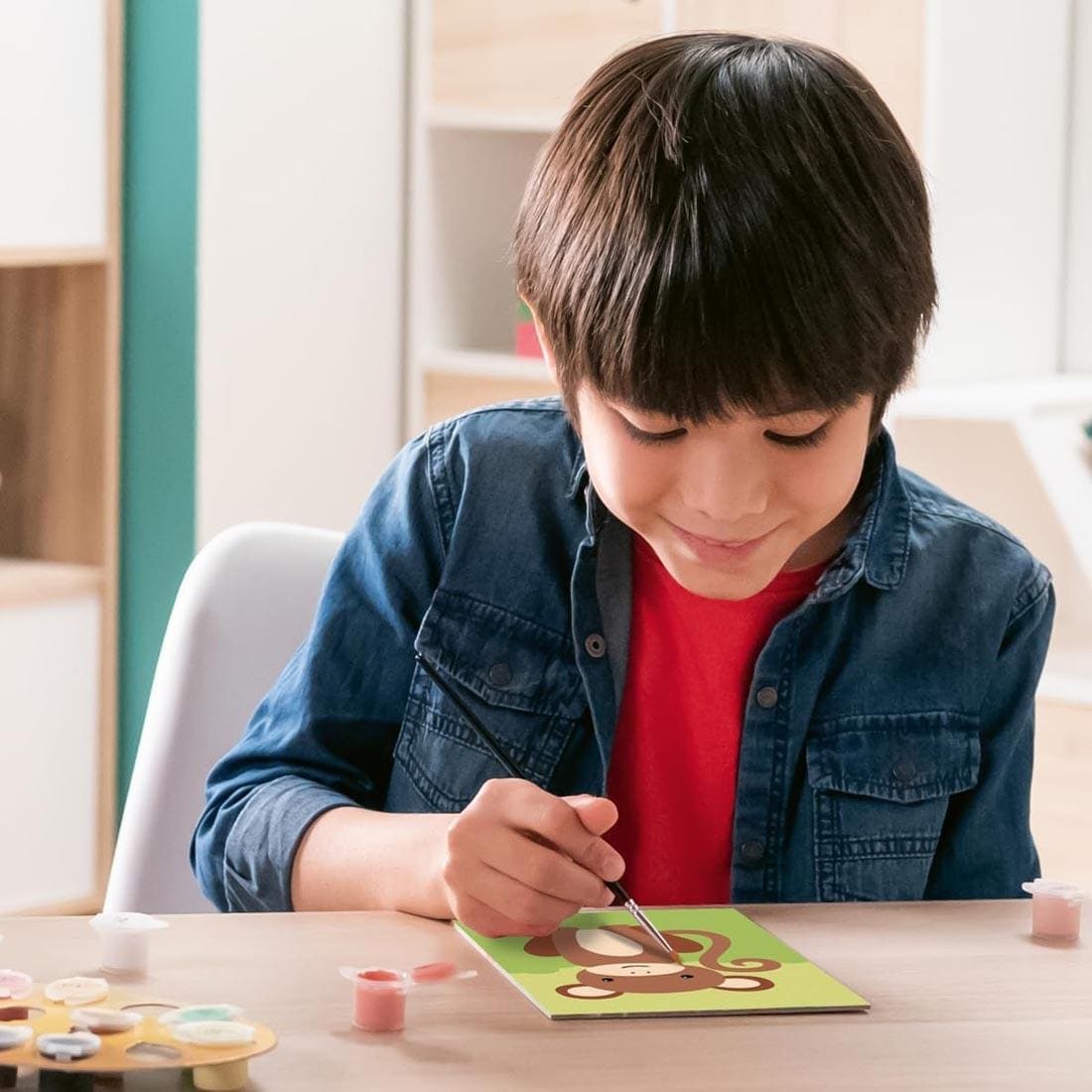 child using the Wild Monkey Kids Paint By Number Set By Ravensburger