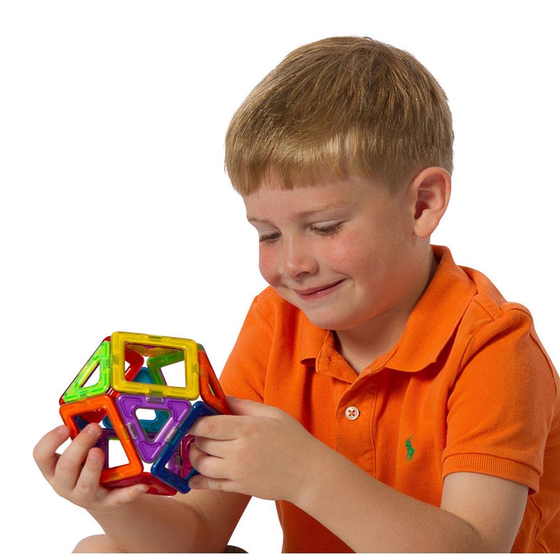 Child holding a sphere made with pieces from the Magformers 30-Piece Basic Set