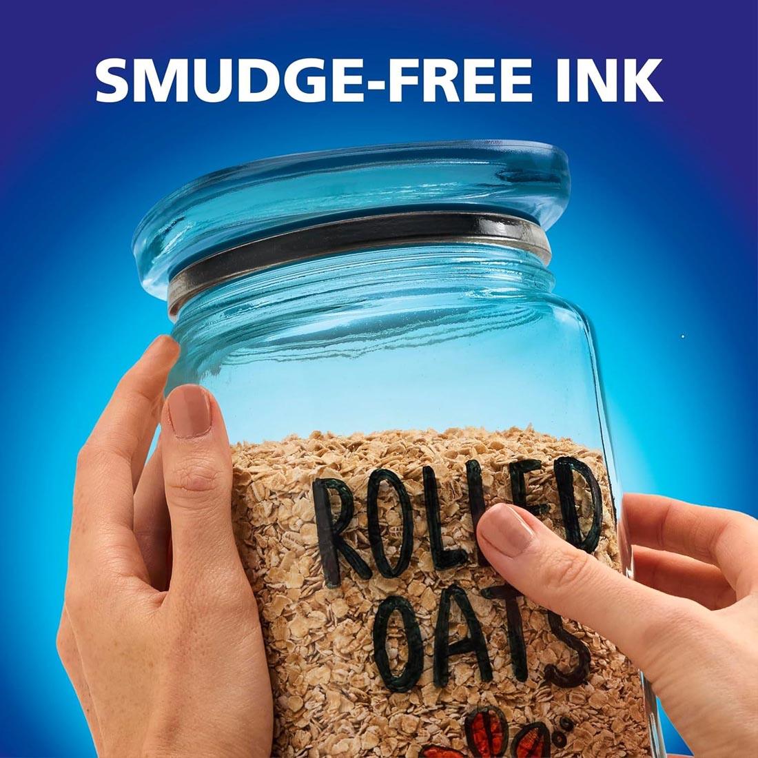 hands holding a glass jar of Rolled Oats with thumb on top of the words, with the words: Smudge-Free Ink