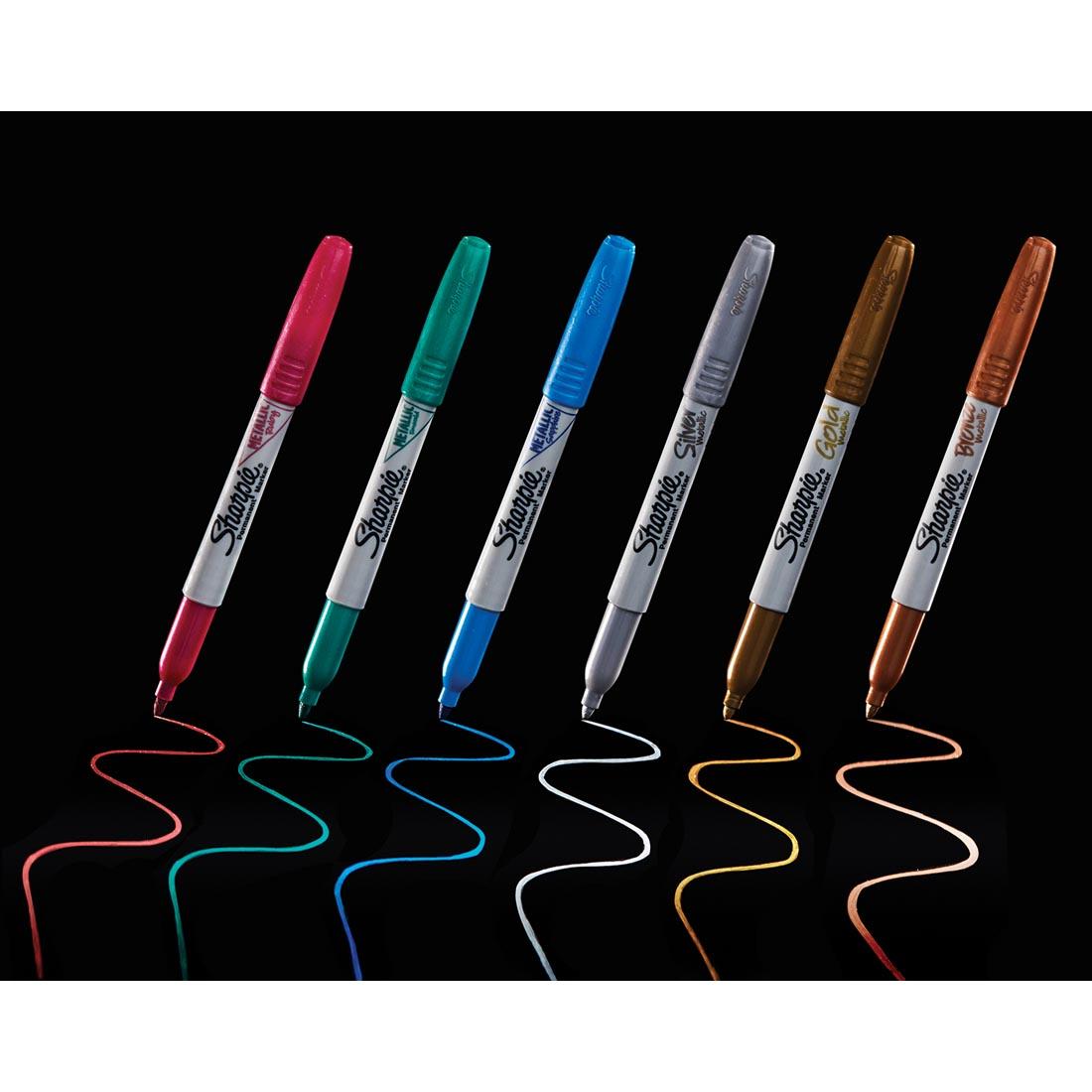 6 colors of Sharpie Metallic Permanent Markers drawing lines on a black background