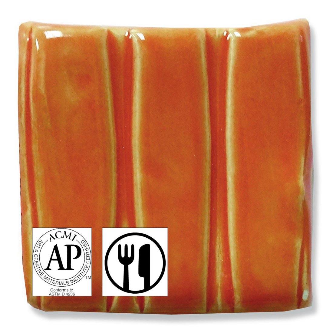 clay tile with Yellow Orange Speedball Low Fire Earthenware Glaze applied; symbols for AP Seal and food safe