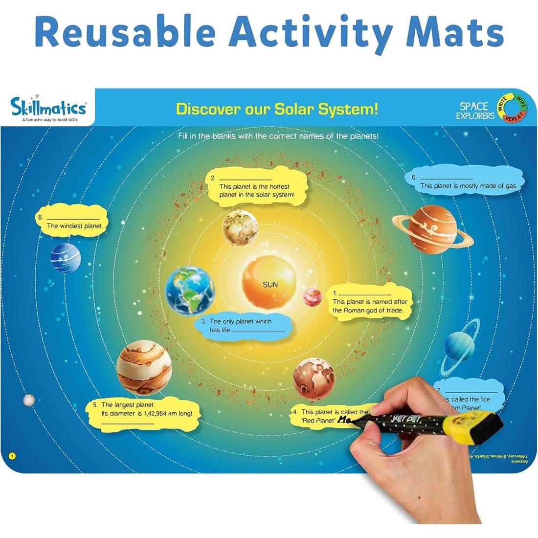 hand writing on one of the Space Explorers Write And Wipe Activity Mats By Skillmatics plus text: Reusable Activity Mats
