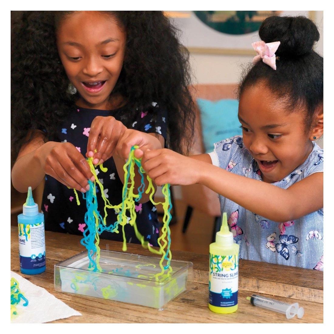 Two children playing with the string slime from the String Slime Starter Set By Steve Spangler Science