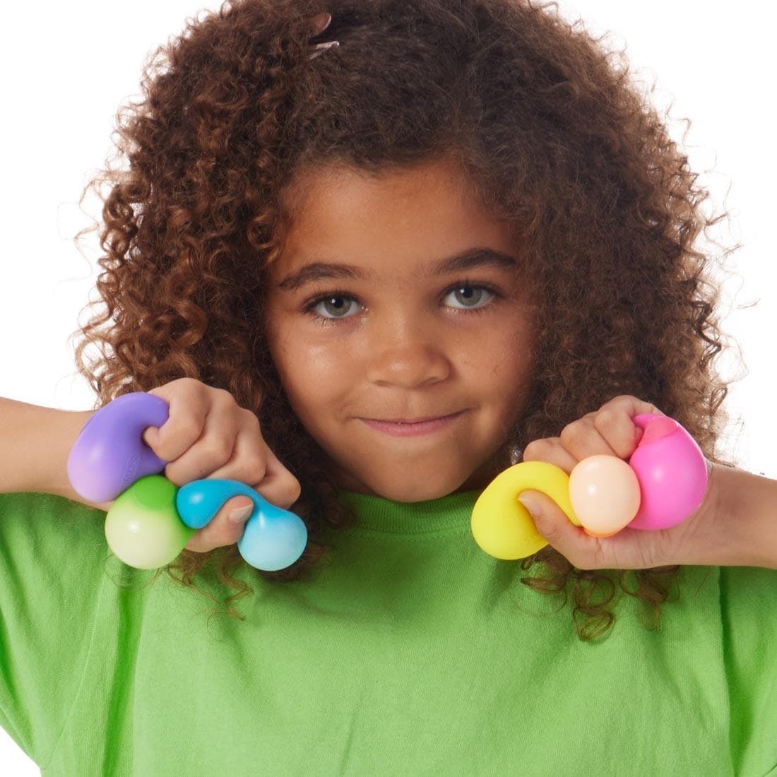 Child squeezing three Teenie Nee Doh Rainboh balls in each hand