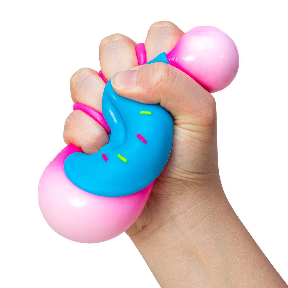 hand squishing a Nee Doh Dohnut