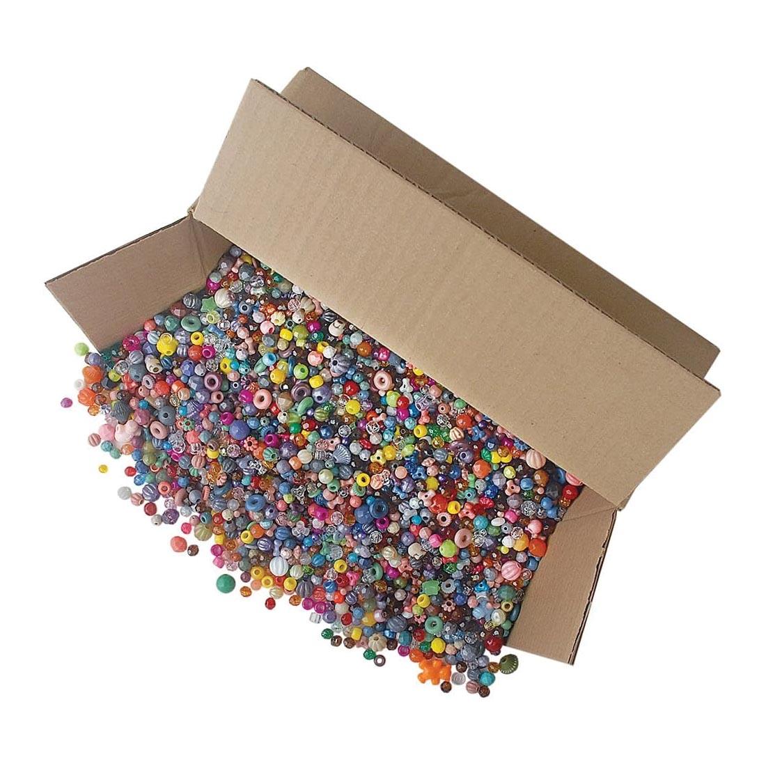 Assorted beads in various sizes, shapes and colors spilling from a cardboard box