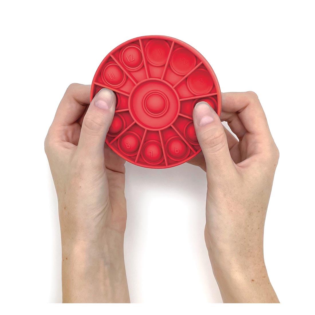 2 hands holding one of the Push And Pop Number Wheels By Teacher Created Resources