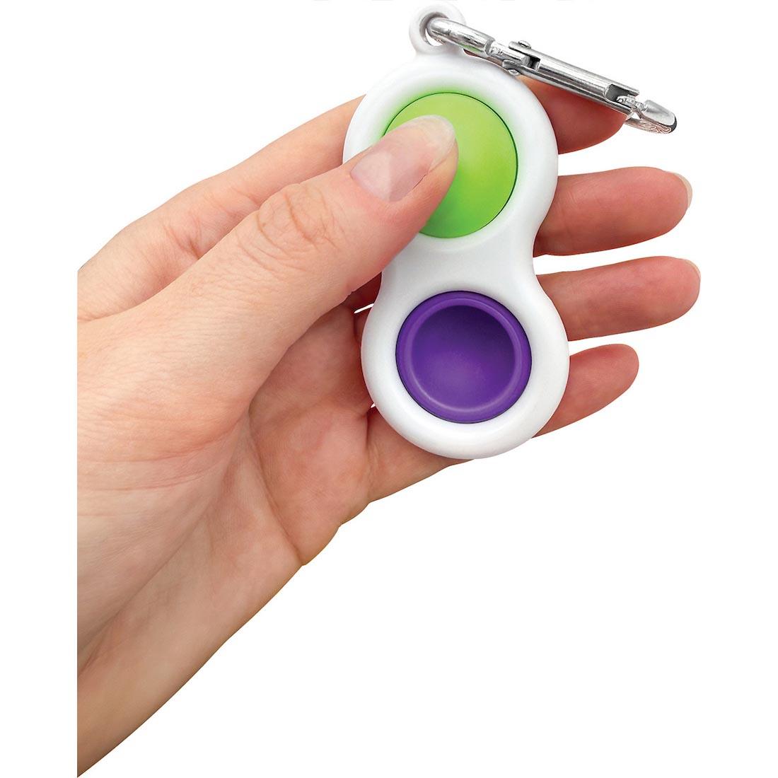 hand holding a Purple And Green Fidget Popper Keychain By Teacher Created Resources