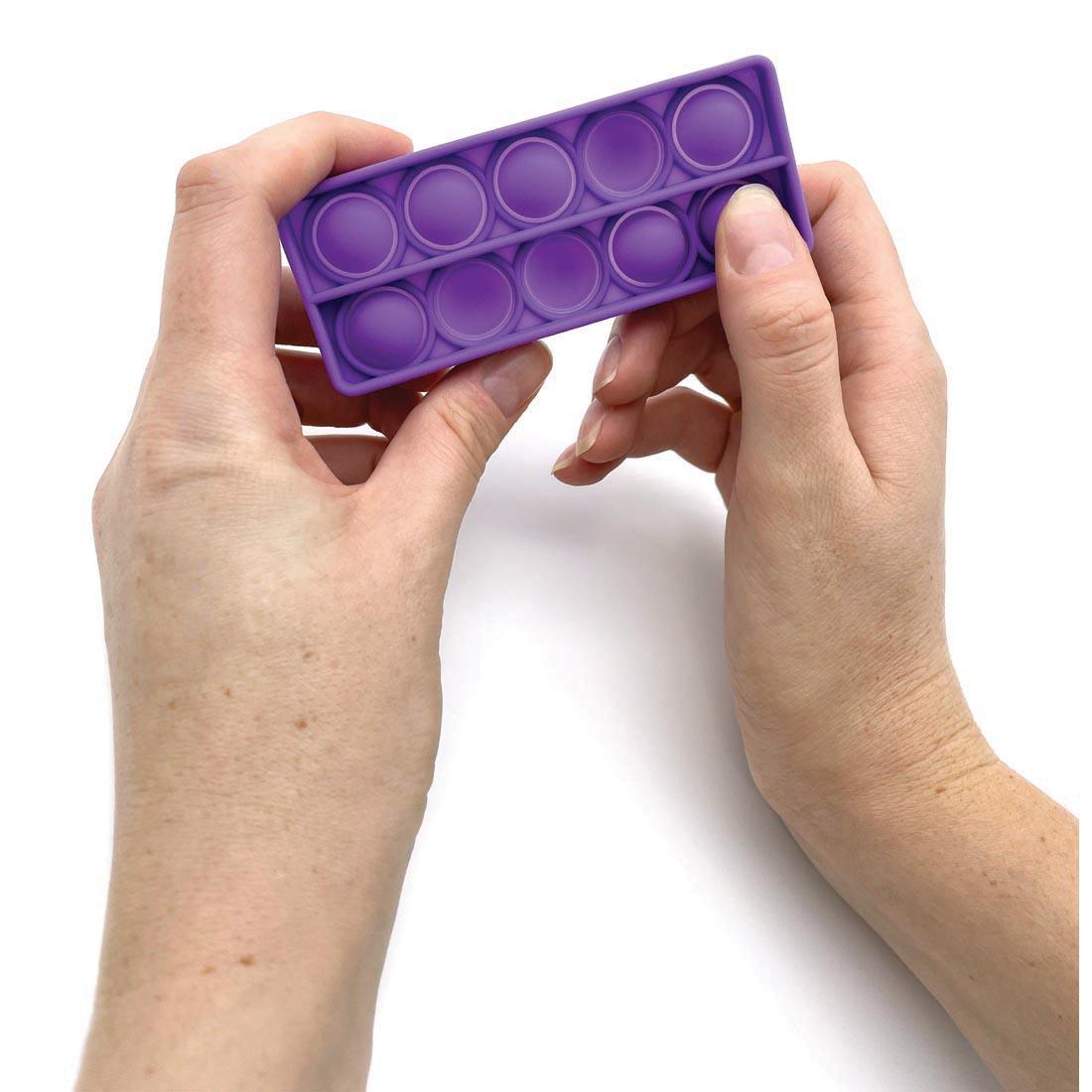 Hands holding a push and pop ten frame from the Sensory Fidget Tools Box By Teacher Created Resources