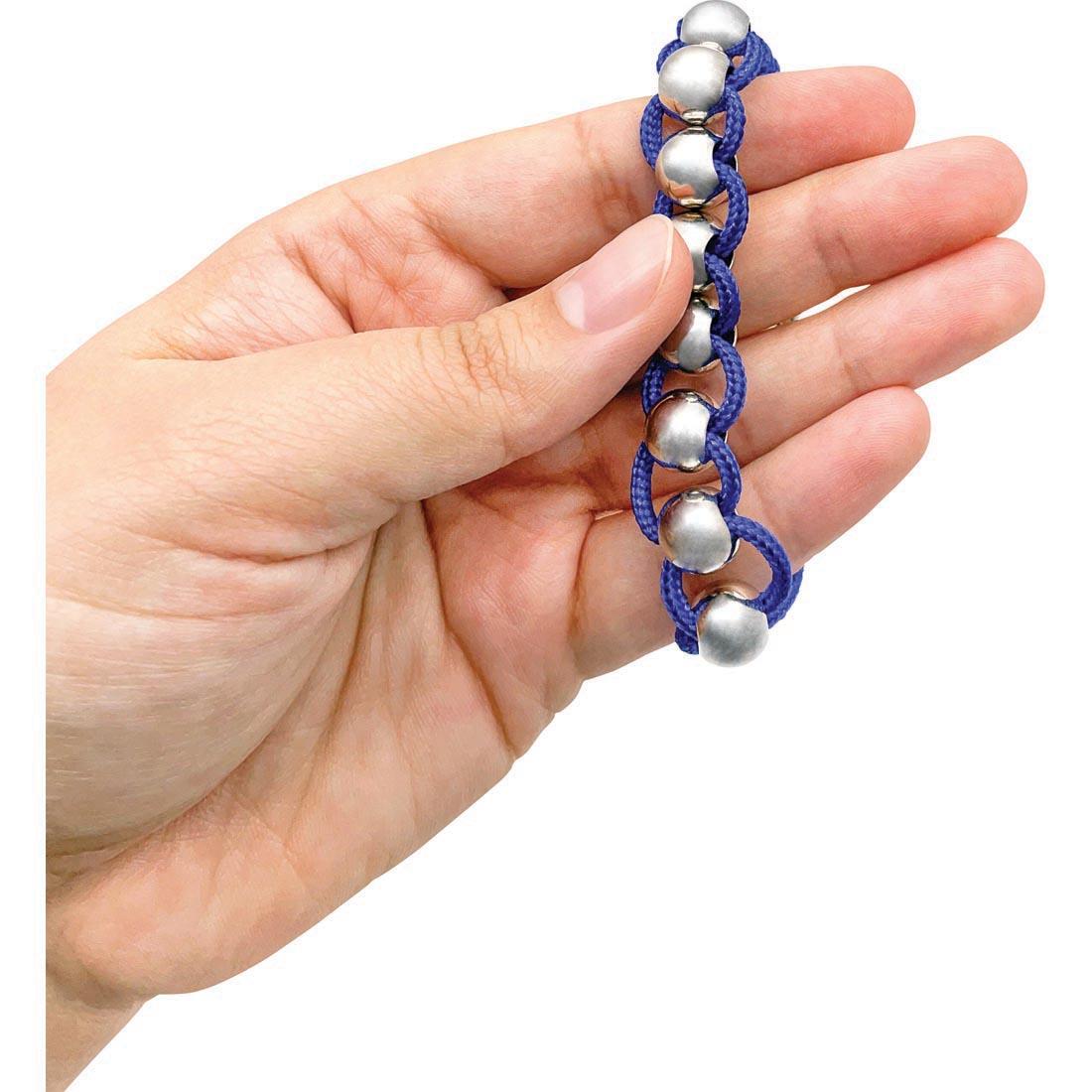 Hand holding a bracelet with rolling beads from the Sensory Fidget Tools Box By Teacher Created Resources