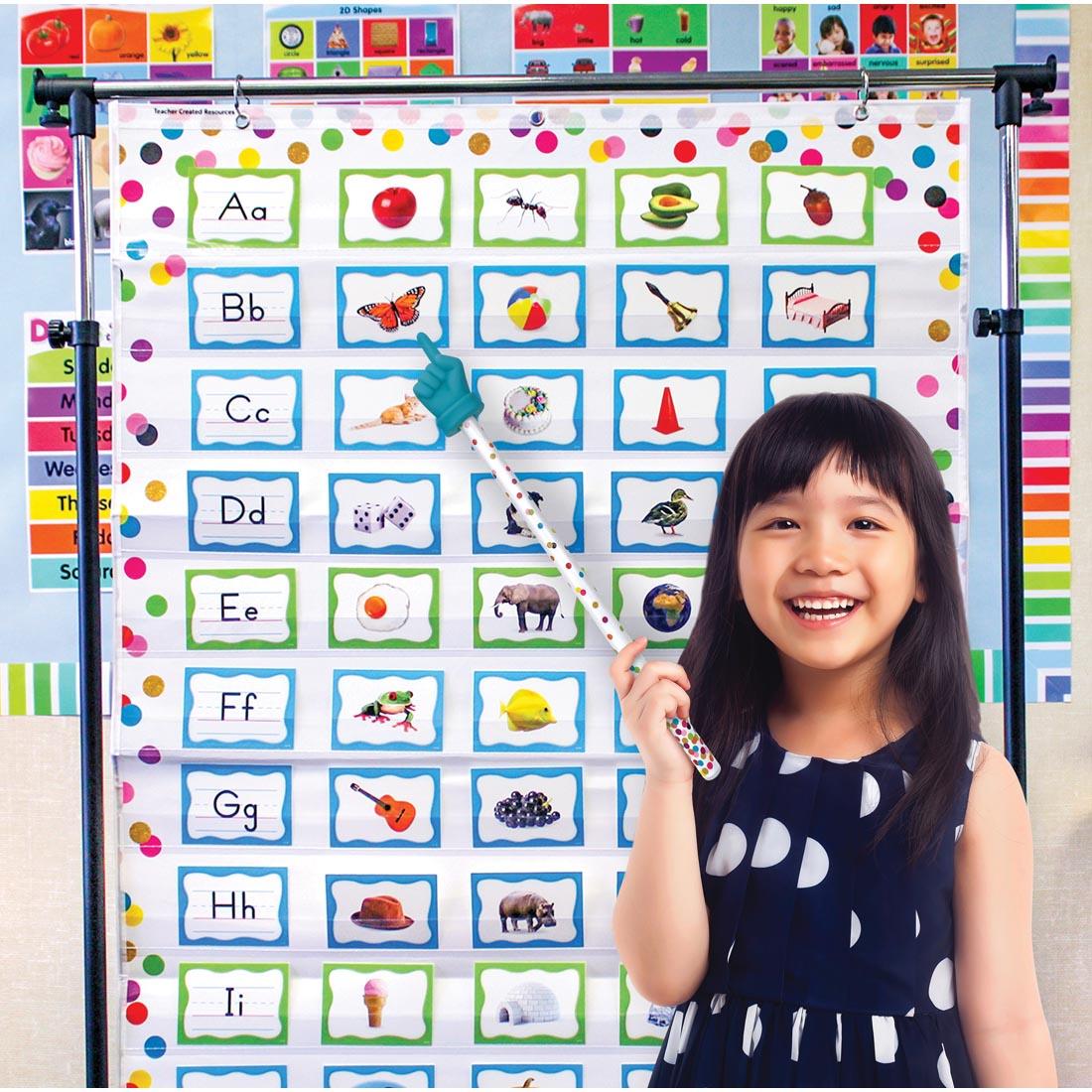 child standing in front of a pocket chart using a Confetti Hand Pointer By Teacher Created Resources