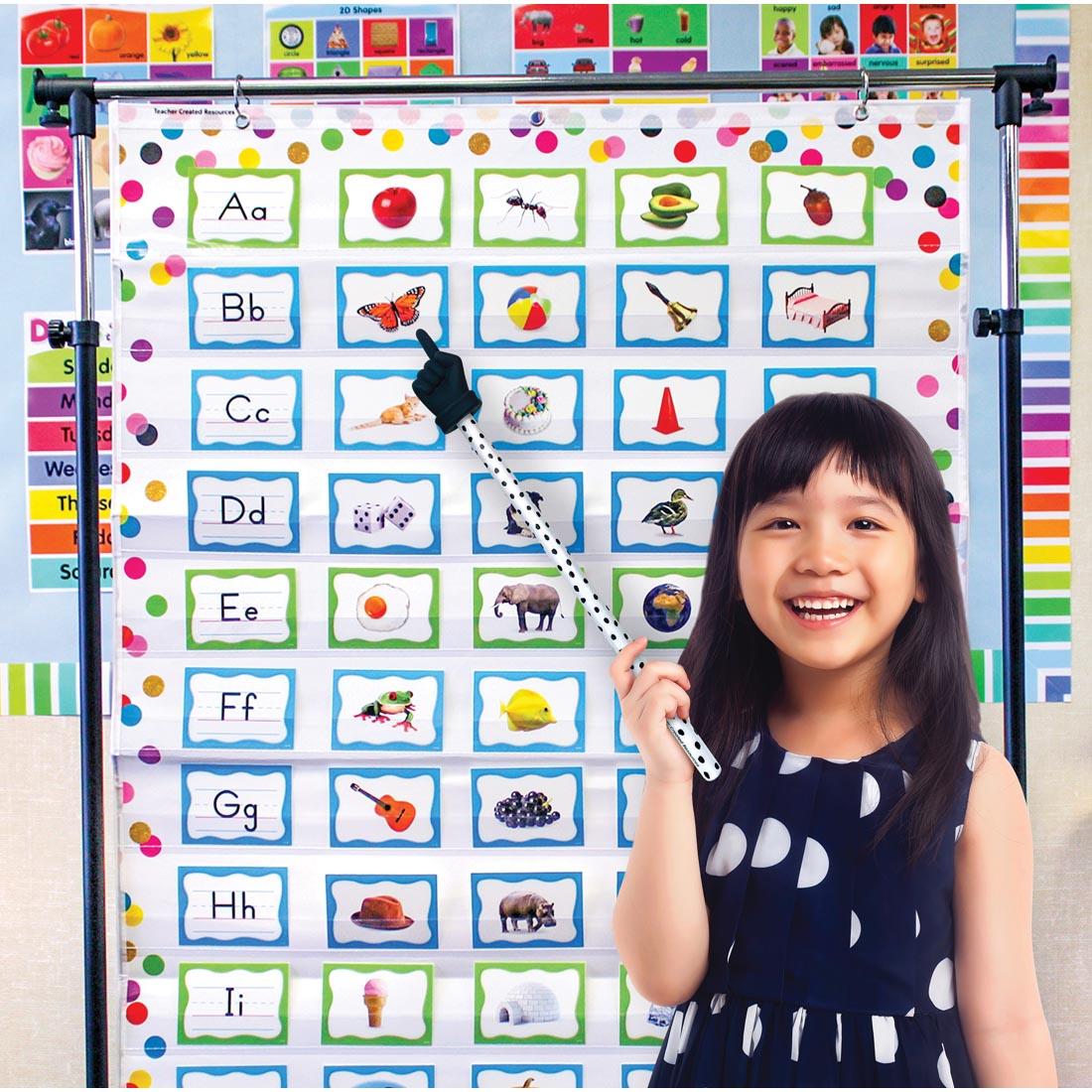 child standing in front of a pocket chart using a Black Painted Dots Hand Pointer By Teacher Created Resources