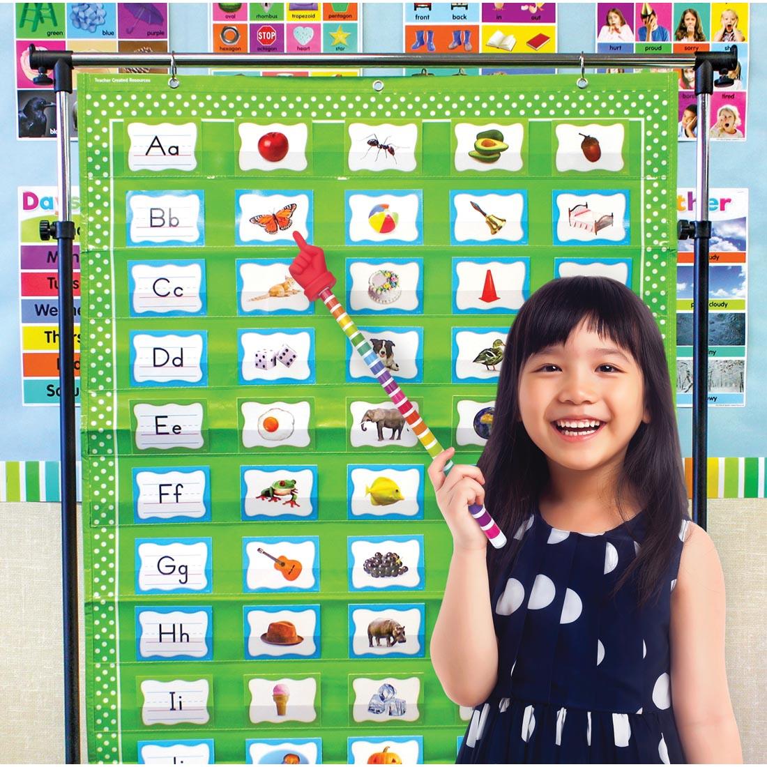 child standing in front of a pocket chart using a Colorful Stripes Hand Pointer By Teacher Created Resources