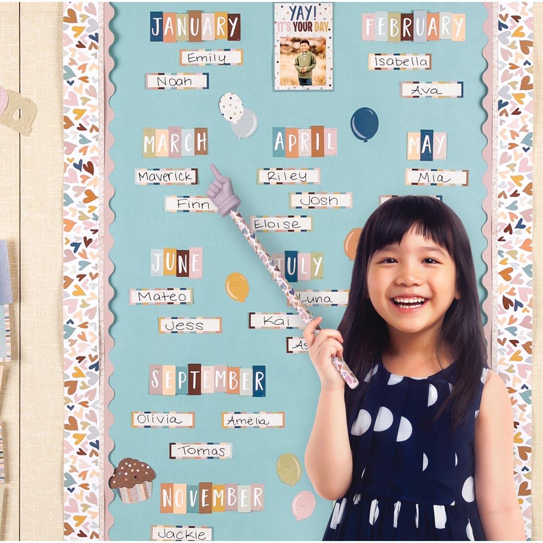 child standing in front of a bulletin board display using a Everyone Is Welcome Hand Pointer By Teacher Created Resources