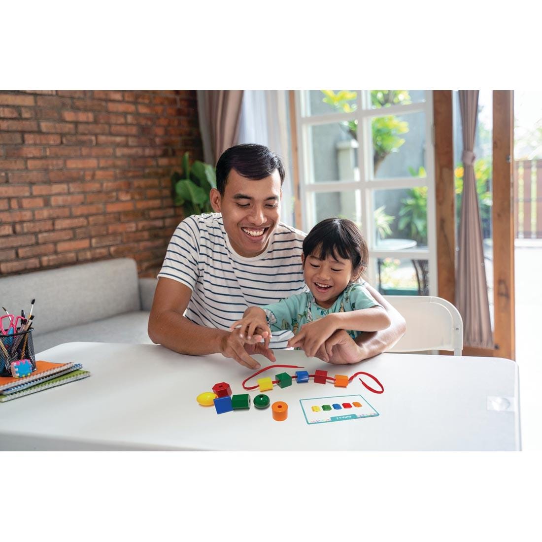child and adult using the Lacing Beads By Teacher Created Resources