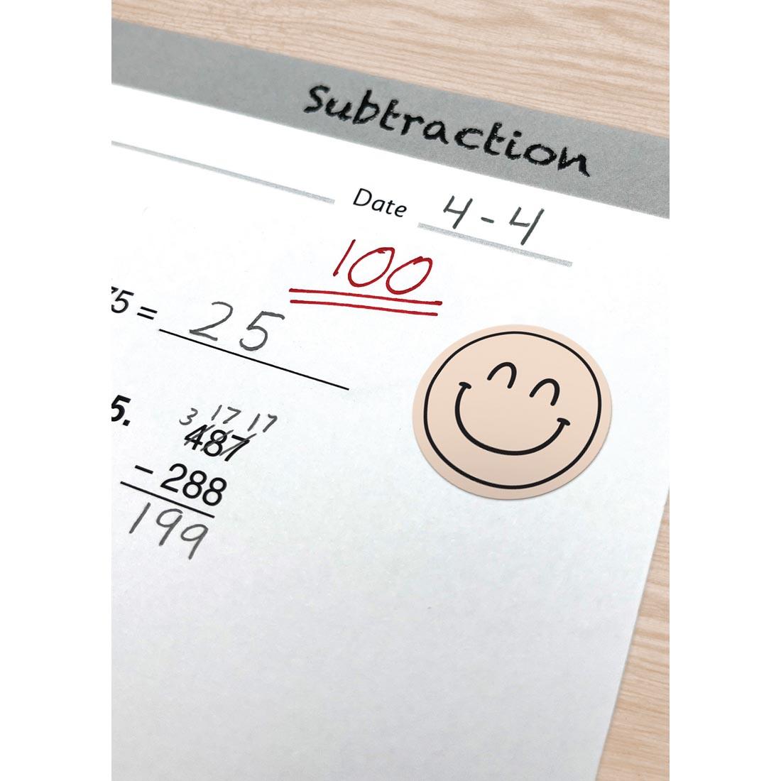 a math paper with a Calming Colors Smiley Face Sticker from the Everyone is Welcome collection by Teacher Created Resources