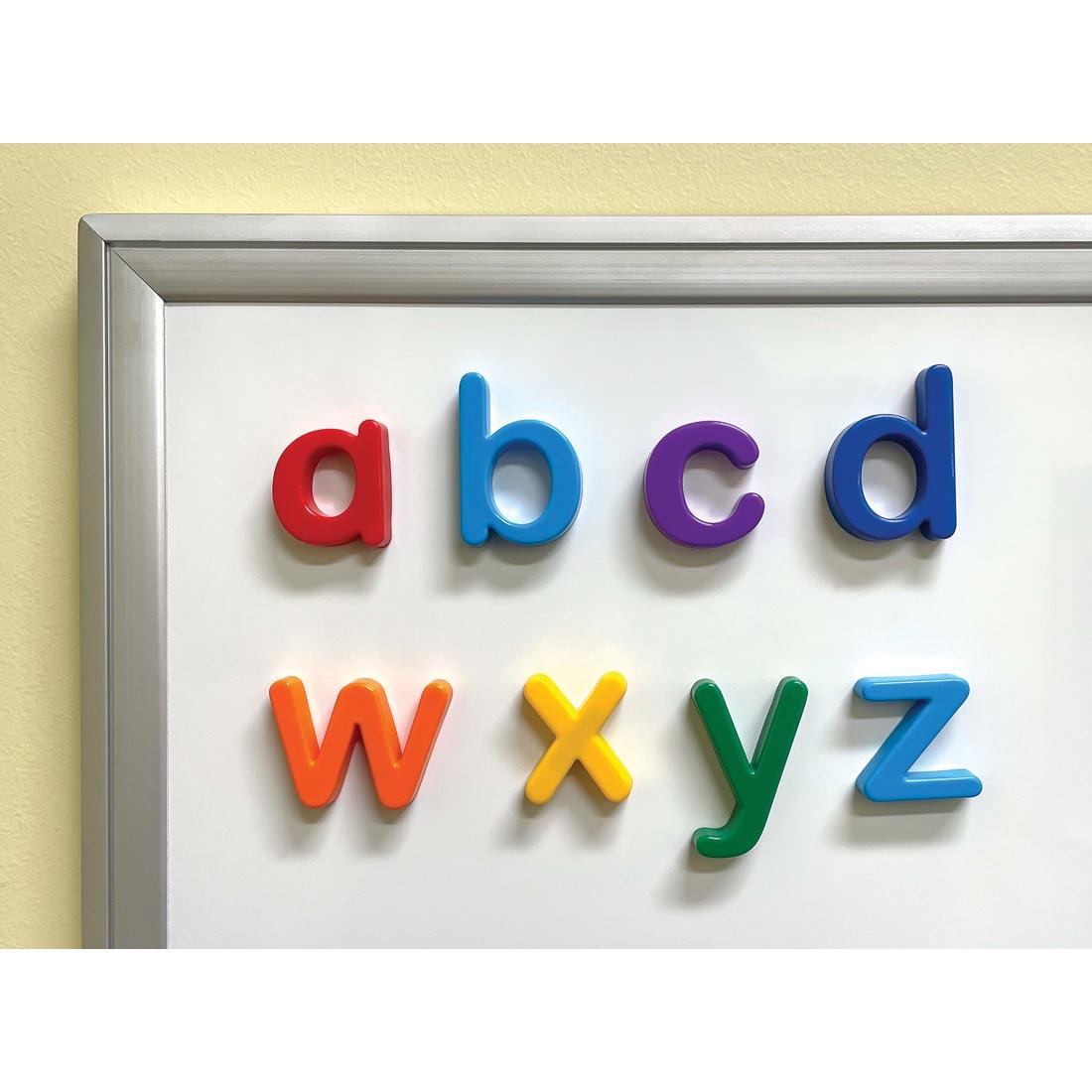 Four Lowercase Magnetic Letters By Teacher Created Resources on a corner of a whiteboard