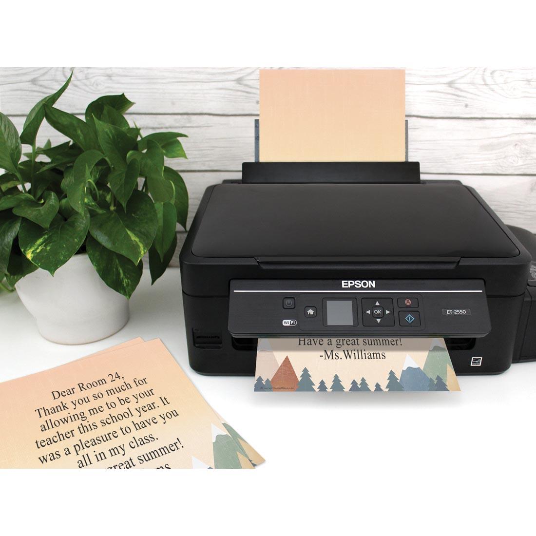 desk with plant and a printer with Computer Paper from the Moving Mountains collection by Teacher Created Resources being printed on