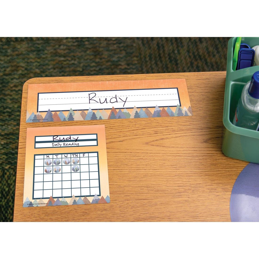desk with a nameplate and a Mini Incentive Chart from the Moving Mountains collection by Teacher Created Resources in use