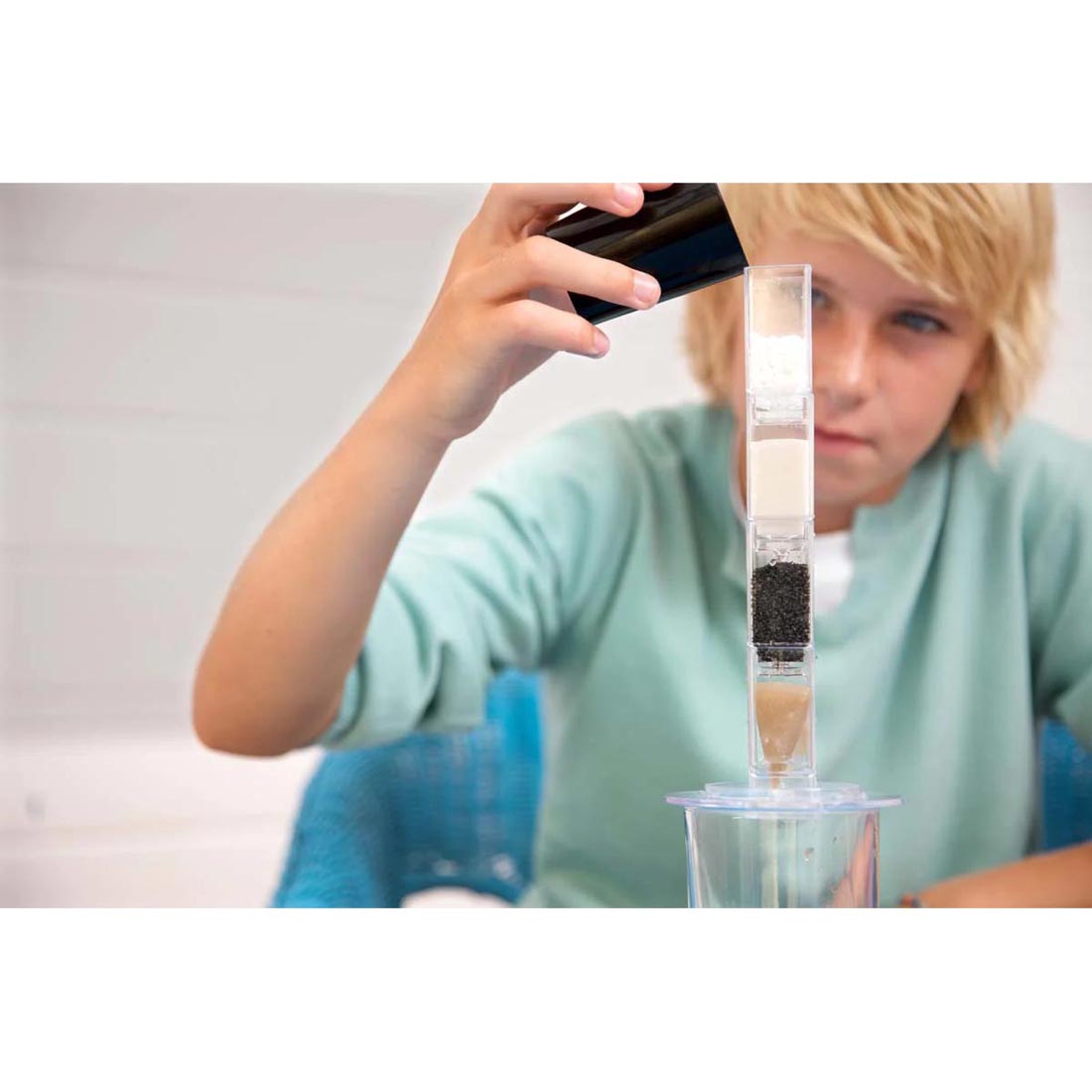 Boy filtering water using 4M Green Science Clean Water Science kit