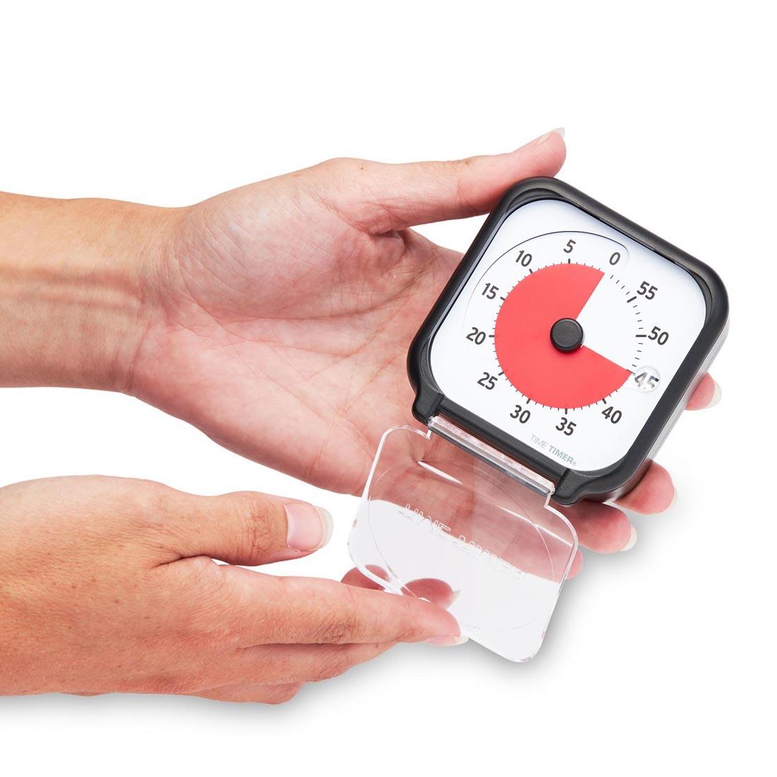 Hands holding the Time Timer 3" 60-Minute Timer with the clear cover open