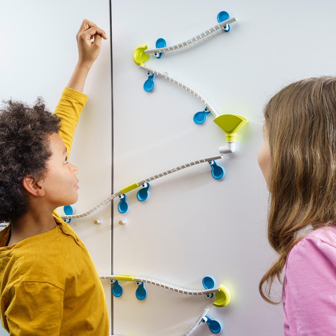 2 kids playing with the Gecko Run: Marble Run Starter Set