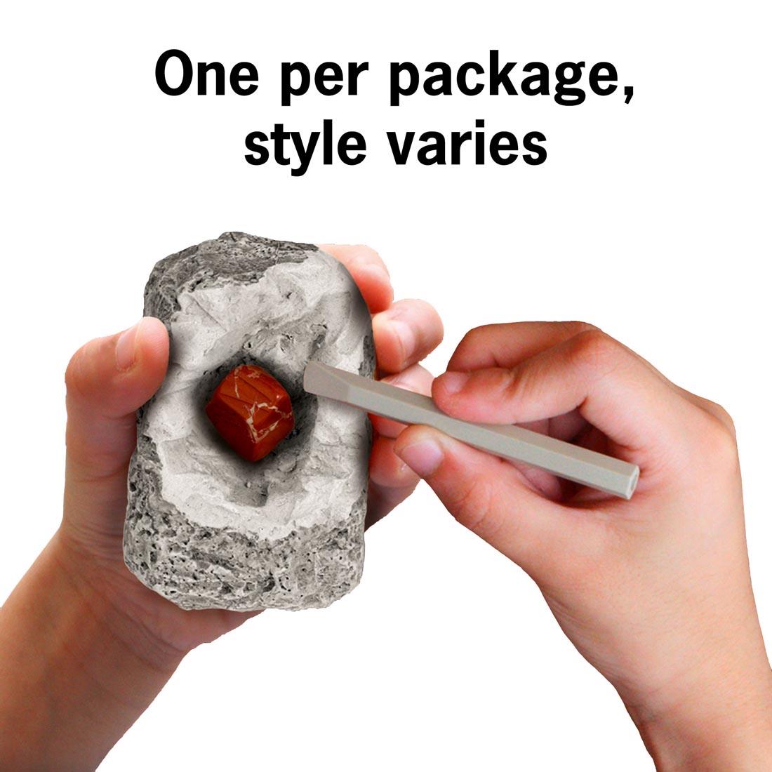 hands holding a specimen from I Dig It! Mineral & Fossil Excavation Kit with text One per package, style varies