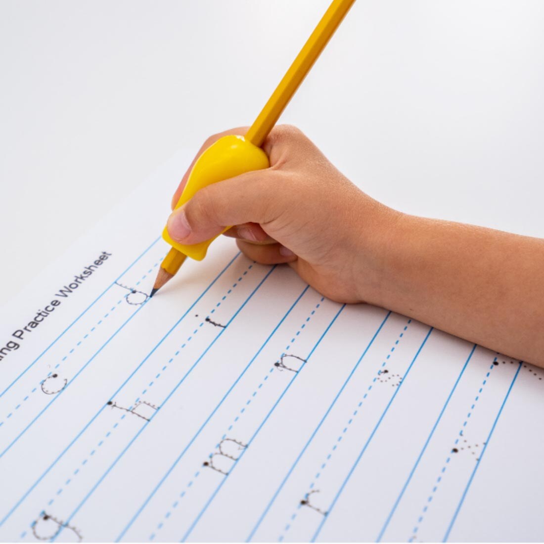 hand tracing letters on a page, using a pencil with The Pencil Grip Jumbo Size Bright grip