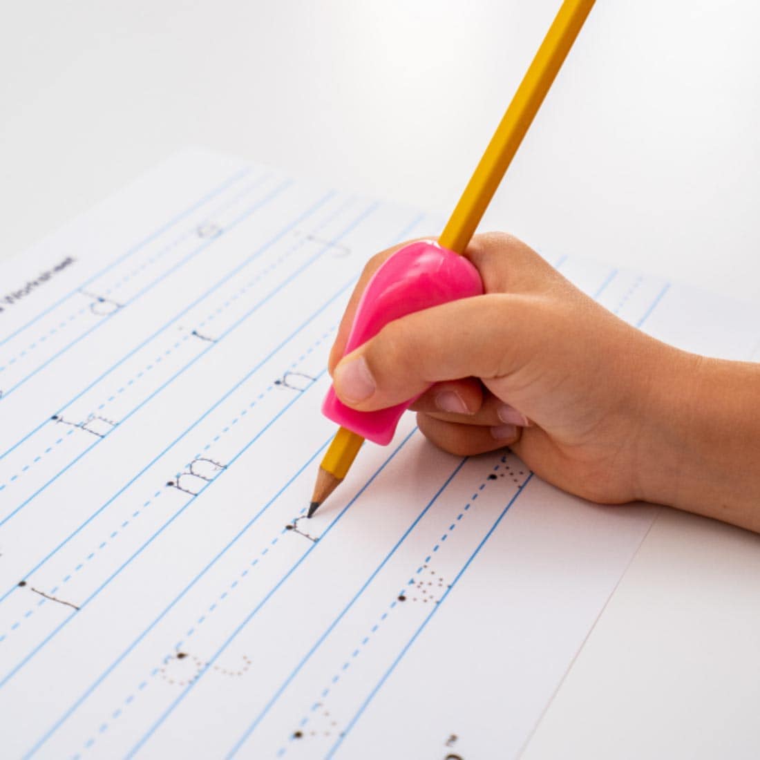 hand tracing letters on a page, using a pencil with The Pencil Grip Jumbo Size Bright grip