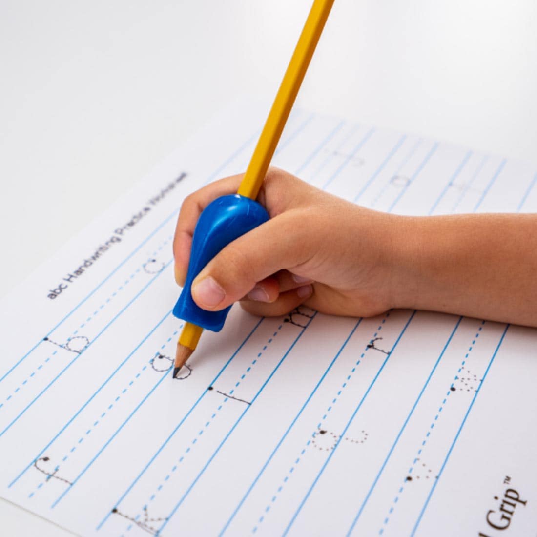 hand tracing letters on a page, using a pencil with The Pencil Grip Jumbo Size Metallic grip