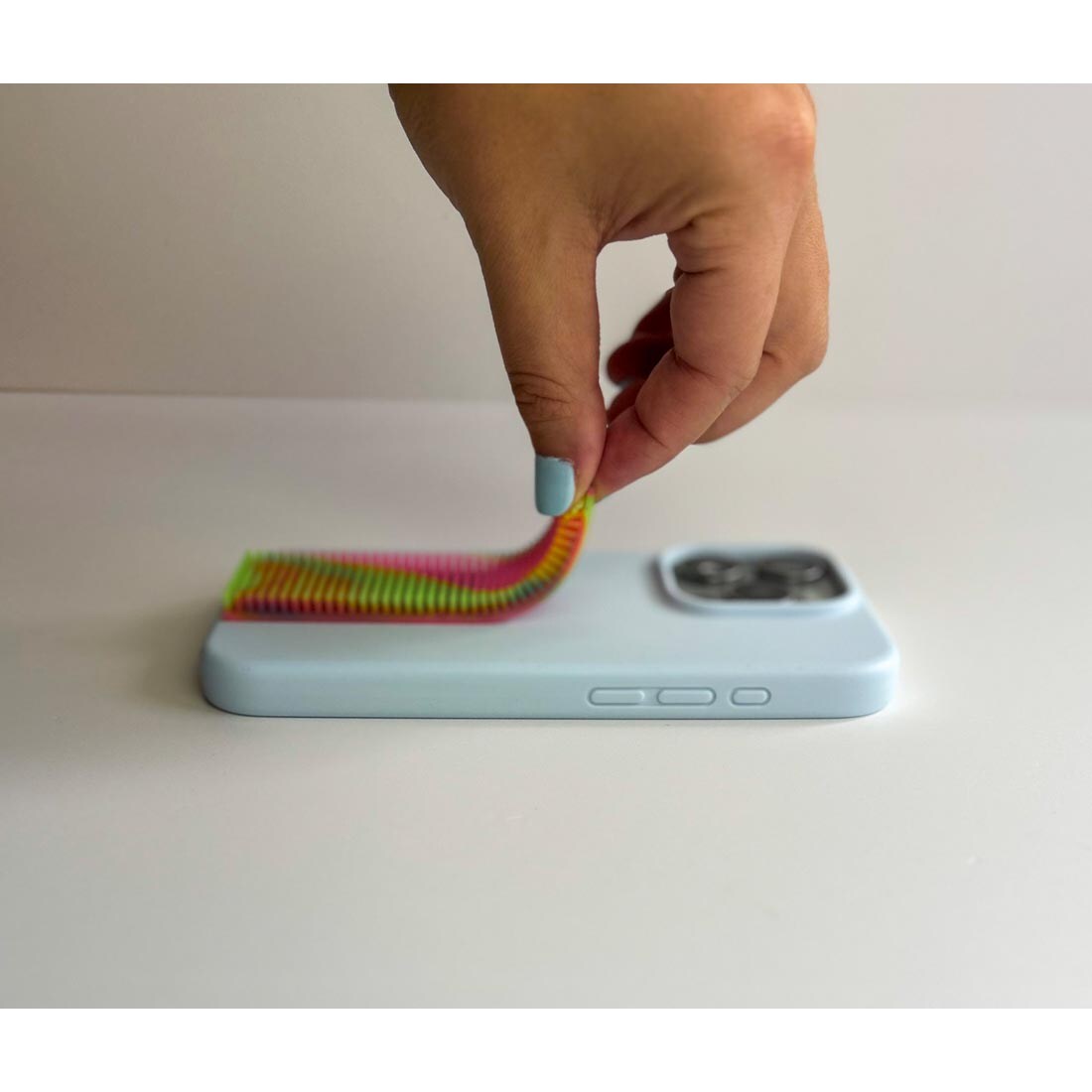 Hand applying a Silicone Multicolor Zen Strip to a cell phone case