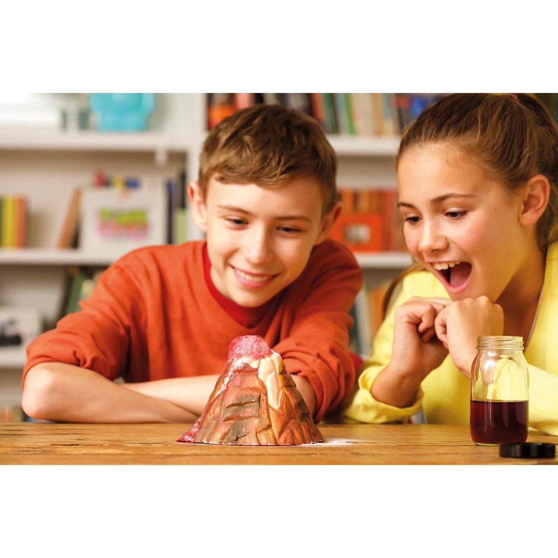 2 kids watching the erupting volcano from the 4M KidzLabs Volcano Making Kit