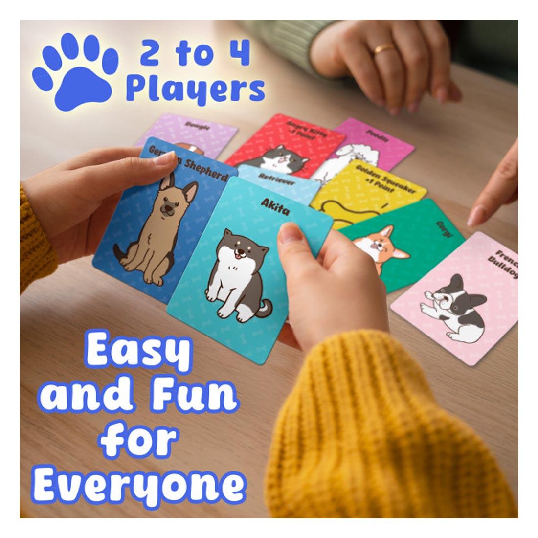 Puppy Pile card game cards on a table, and hands of two players, with the words: 2 to 4 players; Easy and fun for everyone