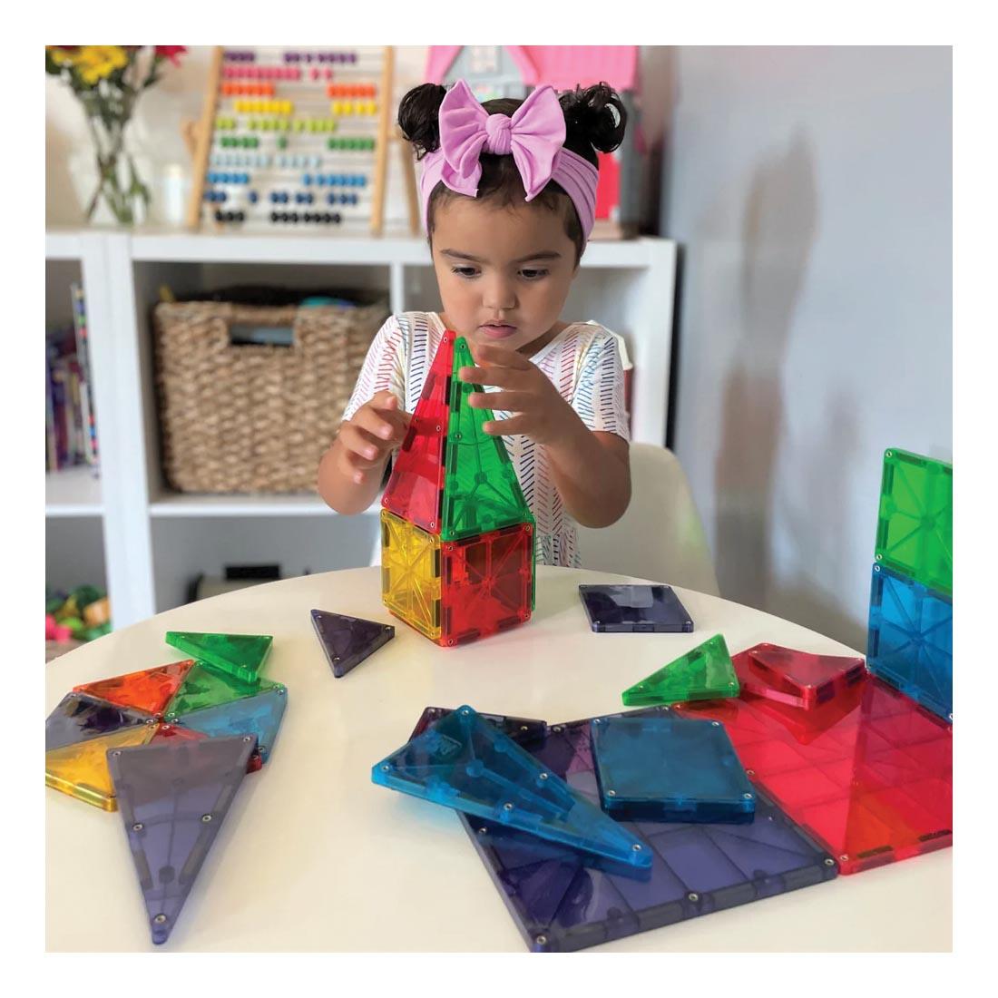Young girl playing with Magna-Tiles Clear Colors 32-Count Set