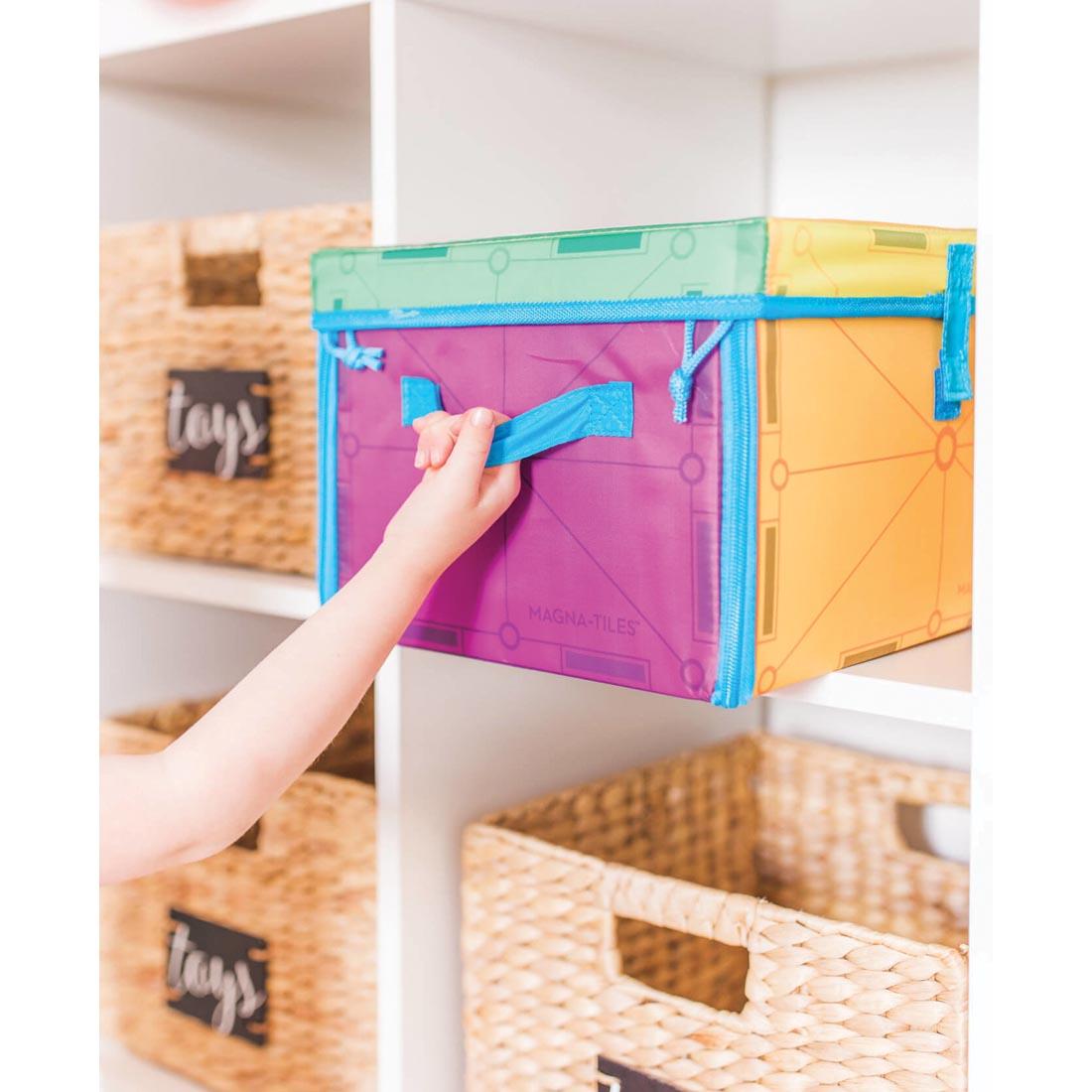 Hand pulling the Magna-Tiles Storage Bin off of a shelf